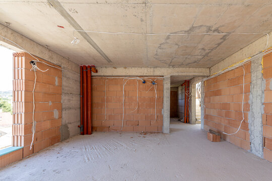 Empty Unfinished Interior Room in New Residential Building with Exposed Brick Walls and Concrete Ceiling, Real Estate Construction Site Ready for Renovation and Design Planning