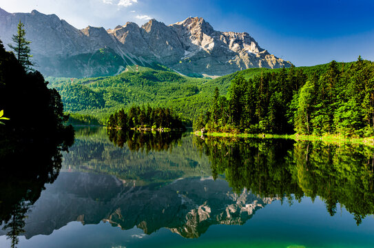 Wasserspiegelung in klaren Bergsee Eibsee in Bayern unterhalb der Zugspitze dem h&ouml;chsten Berg Deutschlands