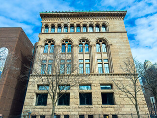 Fototapeta premium Historical building stands tall in the city against a blue sky with clouds during daytime showing stonework and architectural details