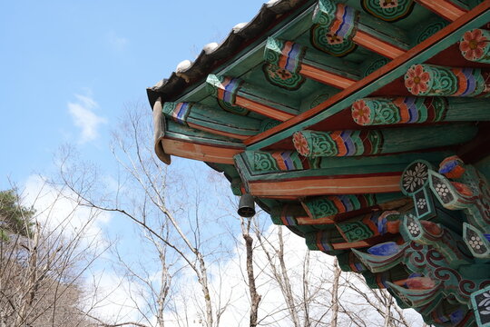 Traditional Korean temple eaves with colorful dancheong under a blue sky
