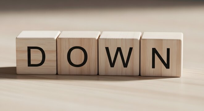 Wooden blocks spell 'down' a conceptual image of decline or negativity