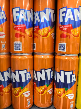 Vibrant display of Fanta cans at a lively grocery store setting