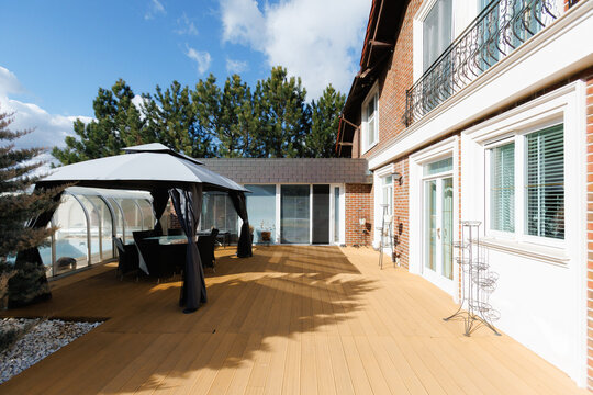 Sunny porch review. Modern deck with tools and planters in daylight