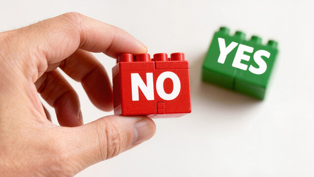 Hand Holding Red NO Block with Green YES Block in Background