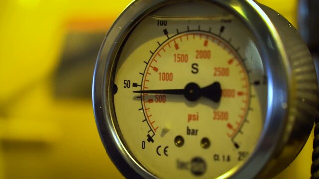 Extreme Close-Up of Industrial Hydraulic Pressure Gauge Showing Bar and PSI Scale. Measurement Instrument on Yellow Heavy Mining Equipment.