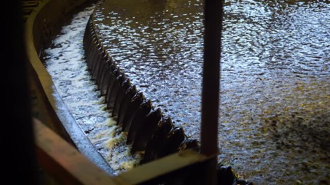 Thickener Overflow Weir with Flowing Slurry Water Inside a Coal Processing Plant. Industrial Water Separation Equipment in a Mining Facility.