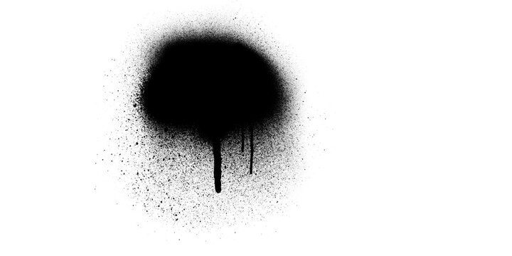 A circular black spray paint mark featuring an intense concentration of pigment with a drip effect