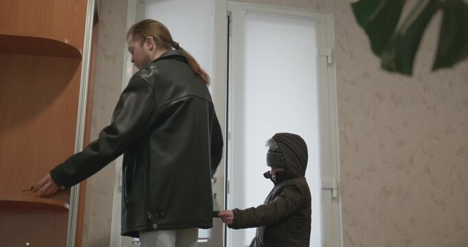 Man and child put on footwear winter shoes. 4K 10-bit