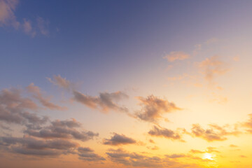 Obraz premium Vibrant sunset sky with colorful clouds in orange, pink and blue hues,A breathtaking panoramic view of the twilight sky during sunset, featuring a dramatic blend of fiery orange, soft pink, and deep.