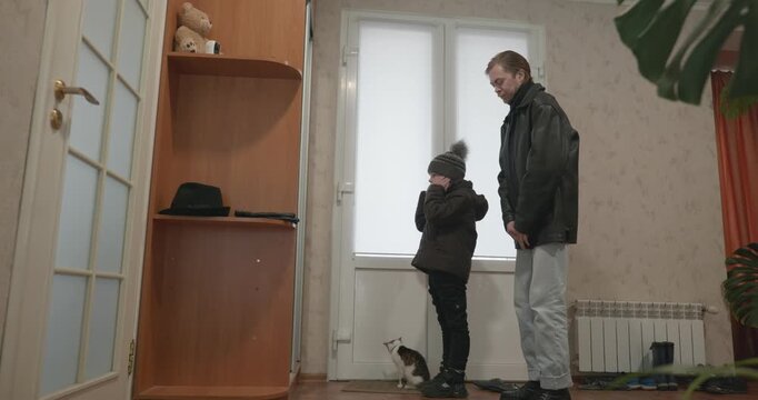Man and child put on footwear winter shoes. 4K 10-bit