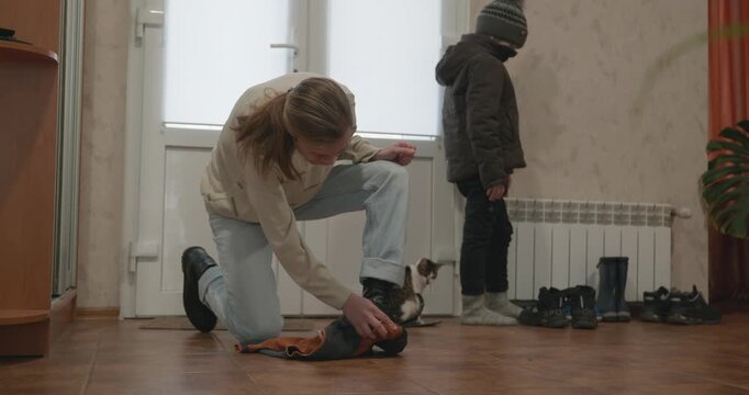 Man and child put on footwear winter shoes. 4K 10-bit