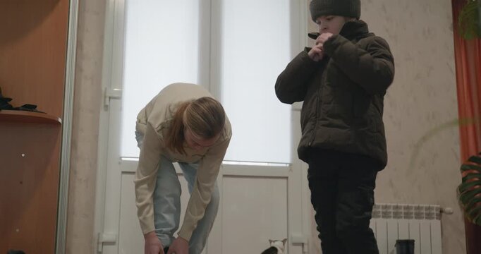 Man and child put on footwear winter shoes. 4K 10-bit