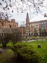 Obraz premium Piazza Marconi in Cremona presenting the Torrazzo bell tower and Stradivarius statue within the city square park green space