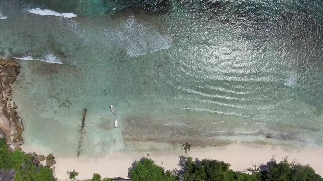 Overhead aerial view of beautiful Seychelles Beach and mountains with boats in La Digue