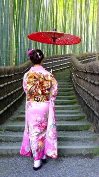 Asian woman wearing japanese traditional kimono at Bamboo Forest in Kyoto, Japan. Vertical