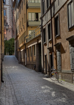 An isolated bike rests on its kickstand in a deserted cobblestone street in old town Stockholm Sweden.