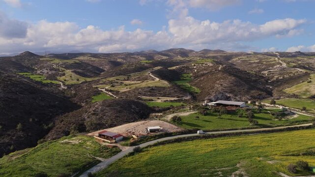 Aerial drone view of rugged hills and valleys with patches of green vegetation in the Cyprus