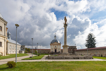 Obraz premium Ancient Dominican monastery with bell tower and Virgin Mary column in Pidkamin
