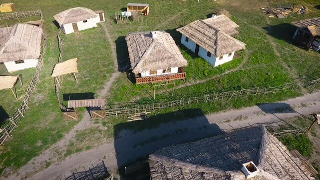 Aerial View of Traditional Thatched Houses Along Village Path in a Historical Cossack Settlement. Drone Shot of Folk Architecture and Dirt Road in Southern Russia.