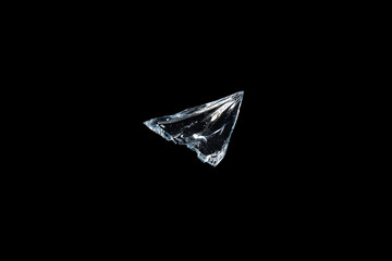 Naklejka premium Shattered Glass: A solitary shard of glass glints and fractures, suspended against an obsidian void. A study of fragility and potential.