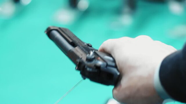 close-up of a person holding a handgun.

Key details:
The firearm appears to be a semi-automatic pistol, held firmly in one hand.
The person&rsquo;s finger is inside or near the trigger guard, suggesting re