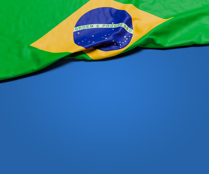 The wrinkled flag of Brazil draped on a blue background with shadow and copy space