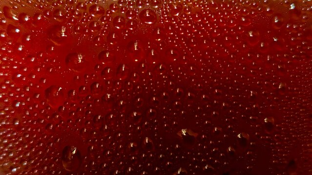 Dehydrated in Detail: A close-up shot of condensation droplets glistening on a deep-red surface, creating a captivating visual texture and emphasizing detail.