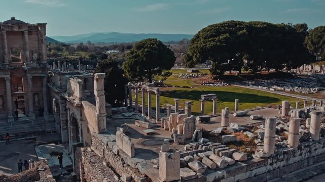 Aerial view of the Library of Celsus and surrounding columns in Ephesus, Izmir, Turkey. Ancient ruins, stone structures and green landscape reveal the grandeur of the Roman heritage site.