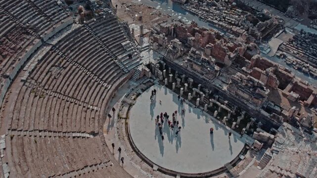 Aerial views of the Great Theatre of Ephesus in Izmir, Turkey. Ancient stone seating, Roman stage ruins and visitors reveal the monumental scale of this historic archaeological landmark.