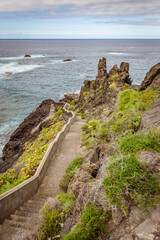 Obraz premium Tenerife coastal path with stone staircase along volcanic cliffs, Canary Islands Spain, dramatic Atlantic Ocean shoreline, scenic hiking route, rugged seascape and travel destination