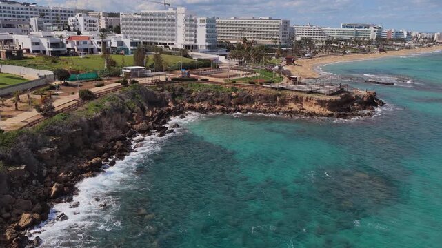 Aerial drone view of seaside hotels and landscaped promenade along the coast, Protaras, Cyprus