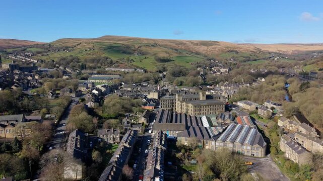 Aerial view of a historic stone textile mill and industrial complex in a Marsden village, Yorkshire 