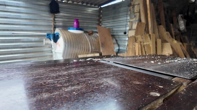 Close-Up of Carpenter Using a Jointer Planer Machine. A professional woodworker processes a pine plank on an industrial surface planer. This shot captures manual labor, craftsmanship
