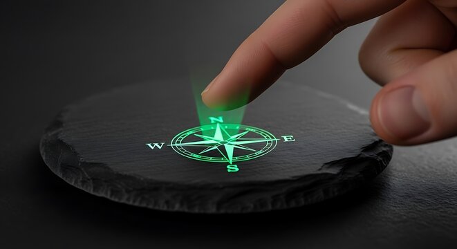 Finger pointing at glowing green compass rose on dark stone representing guidance and direction.