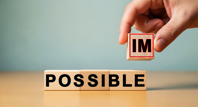 Hand placing a wooden block with the letters im to change impossible to possible