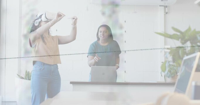 Headset user initiating VR gestures, expanding motions, colleague guiding via laptop for tech demo