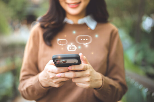 Close-up of a happy woman using a smartphone to interact with an AI chatbot assistant, demonstrating digital transformation, automated customer service, and smart technology integration