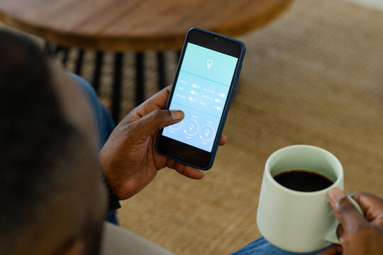 Blue-case smartphone is showing lighting app at home on table by white mug on beige rug