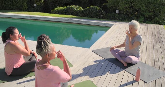 Senior African American instructor leading diverse women breathing, reaching on mats, copy space