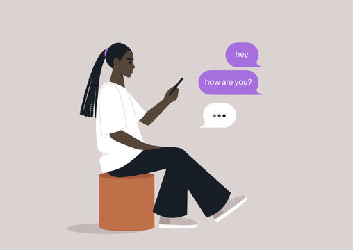A young individual is sitting comfortably on a pouf, deeply engaged in a smartphone conversation, The casual setting invites a sense of calm and connection with friends.