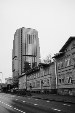 Contrast between old wooden houses and a modern skyscraper