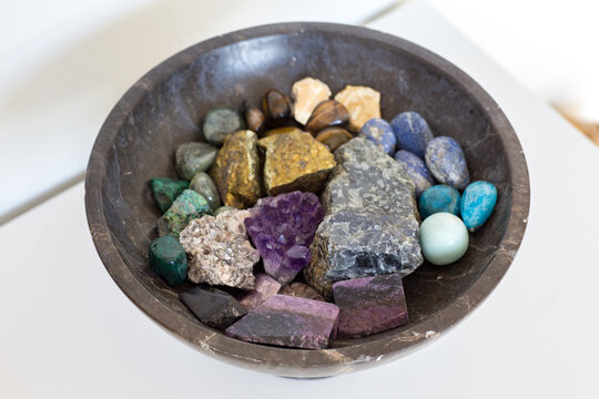 Close-Up of Vibrant Gemstones in a Polished Marble Bowl. Gemstones Rest Elegantly in a Black Marble Bowl