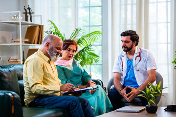 Obraz premium Indian doctor presenting a legal medical document for an elderly Asian couple to sign.