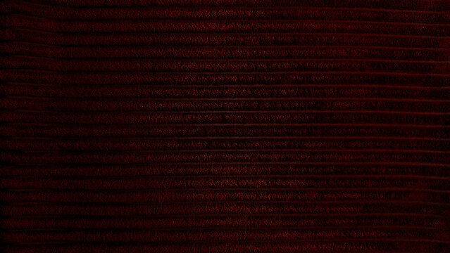 rich dark red corduroy texture closeup captures horizontal ridges in mysterious moody atmosphere