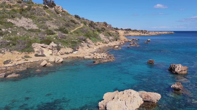 Aerial drone view of a quiet Konnos Beach rocky bay with crystal clear turquoise water in Cyprus