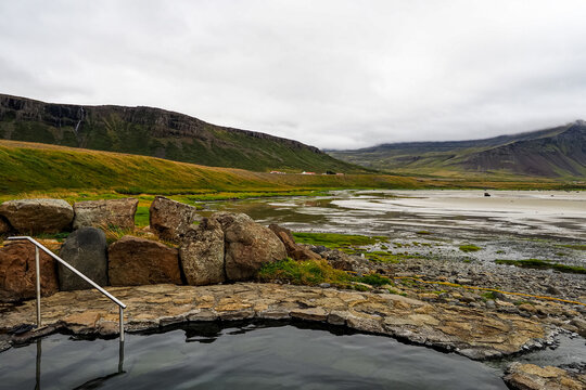 Wild Icelandic landscape. Krosslaug of Birkimelur, natural geothermal pool or authentic hot spring, with beautiful views to the bay and sandy beach. Bardastrandarvegur, Westfjords peninsula, Iceland.