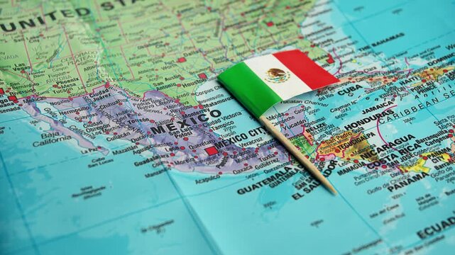 Hand adjusts Mexico flag on detailed Central America map