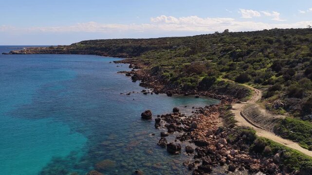 Aerial drone view of a quiet Konnos Beach rocky bay with crystal clear turquoise water in Cyprus