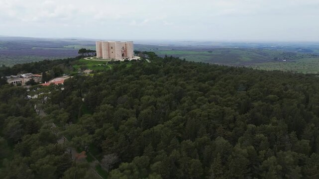 Aerial view from a drone flying away from the fascinating and mysterious Castel del Monte, a 13th-century citadel and castle situated on a hill in the Apulia region of southeast Italy.