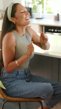Laughing woman gesturing and leaning toward counter on bar chair, reacting to off-frame joke